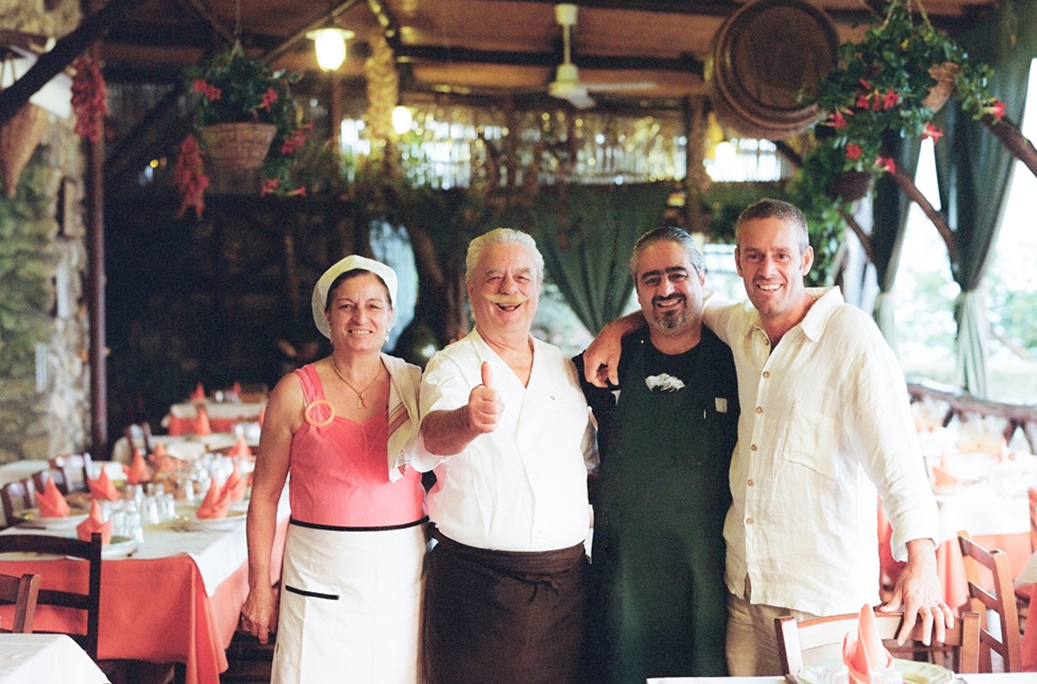 italian family huddled together and smiling inside a restaurant